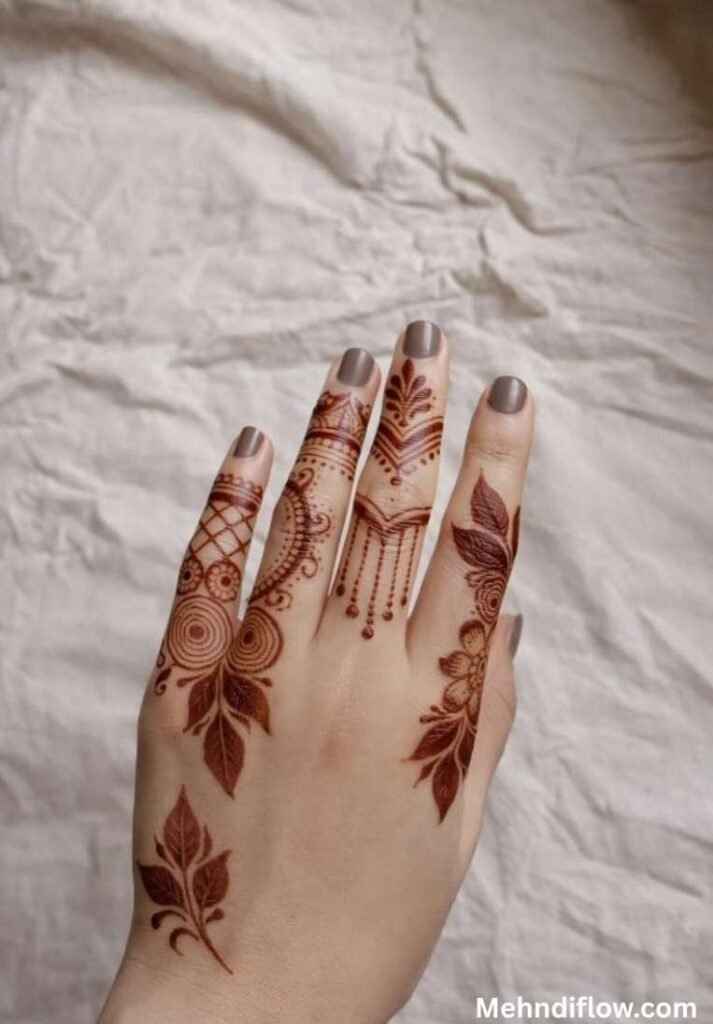 Minimalist back hand mehndi design featuring delicate leaf motifs and fine line finger patterns