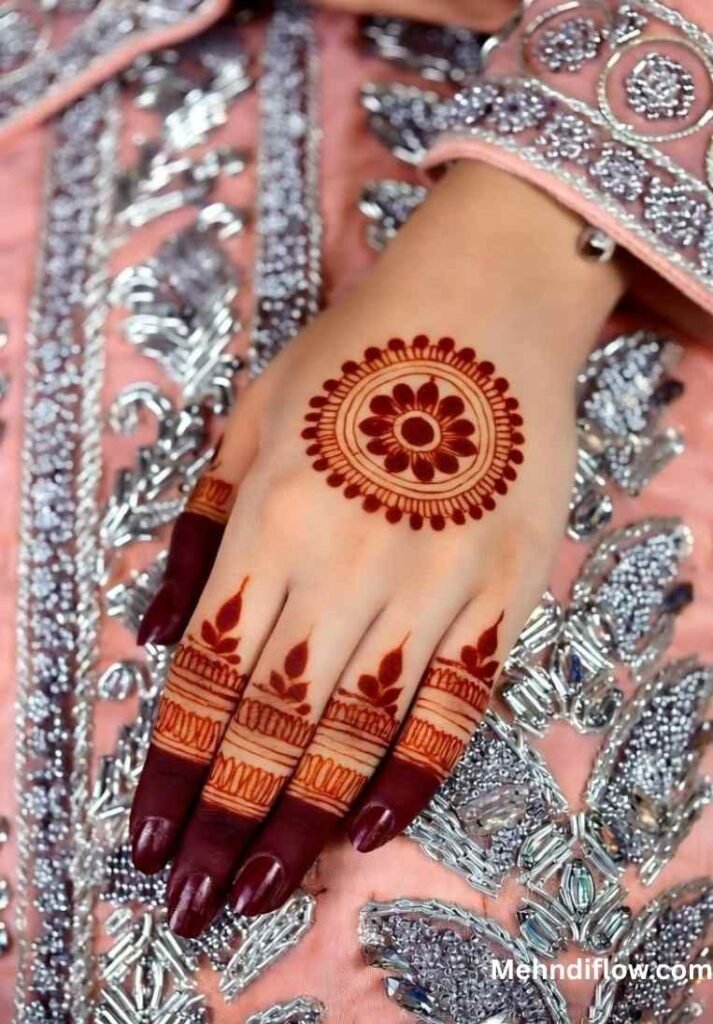 Hand with a vibrant, circular floral tikki motif and detailed finger tips.