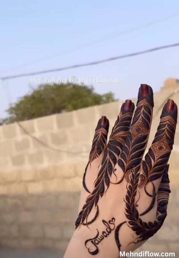 Close up of the back of a hand featuring a striking mehndi design with bold, flowing leafy vine trails covering the fingers, paired with the name 'Jawad' written in a clean, stylish cursive script near the wrist.