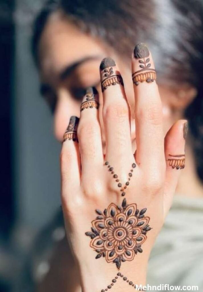 Minimalist mandala back hand mehndi design with a delicate dotted chain connecting to finger caps