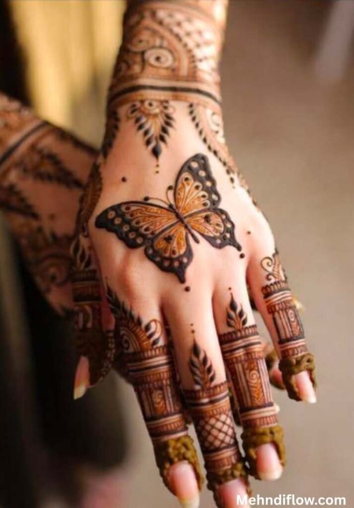 Dense Rajasthani-style bridal henna design showcasing a prominent shaded butterfly, heavy geometric finger patterns, and an elaborate wrist band.