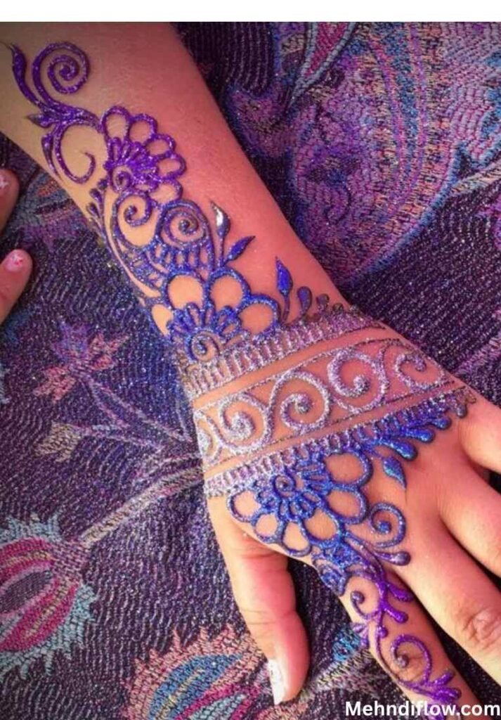 Elegant bridal purple glitter mehndi design with large floral motifs and swirls on the back of the hand.
