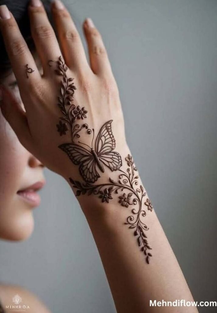 Elegant butterfly mehndi design featuring a delicate, trailing floral vine on the back of the hand and wrist.