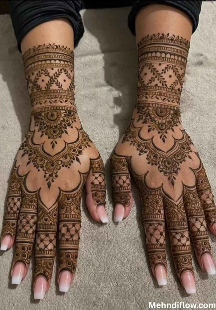 Matching detailed bridal henna on both back hands featuring heavy cuffs and lattice finger patterns.