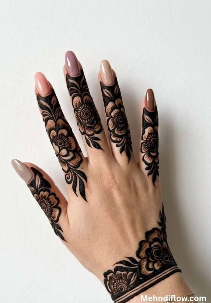 Intricate finger mehndi design featuring dark floral caps and a matching floral wrist cuff