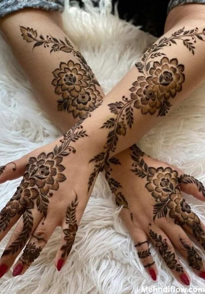 A pair of hands crossed over each other, displaying intricate, dense floral trail mehndi designs that flow from the wrists up to the fingers.