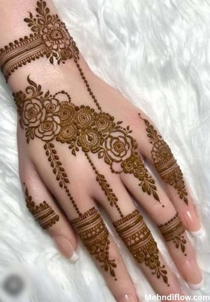 Diagonal rose vine back hand henna with delicate dotted chains.