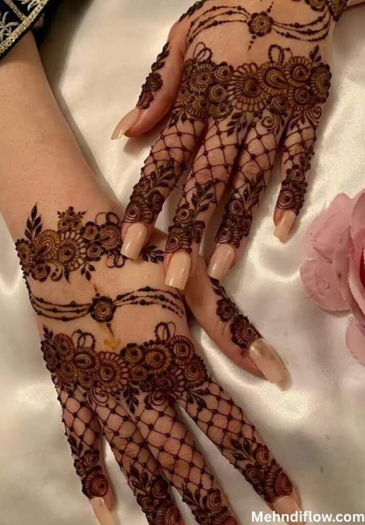 Hands featuring intricate net and lace mehndi patterns with floral accents.