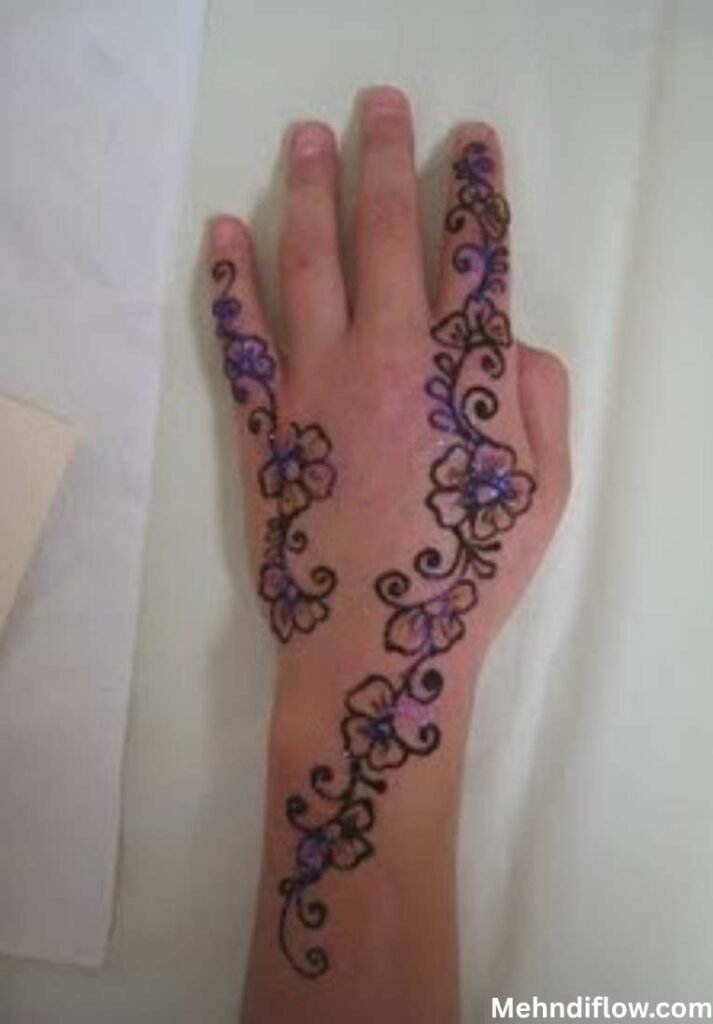 Simple purple glitter mehndi design with floral trails on the back of a hand. - Purple Glitter Mehndi Design