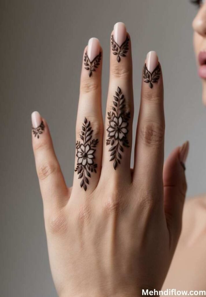 Fingers adorned with delicate, statement leaf and floral mehndi patterns.