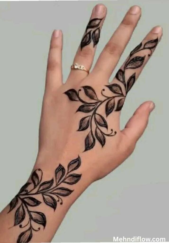 A hand showcasing a bold, tropical leaf mehndi design across the back of the hand.