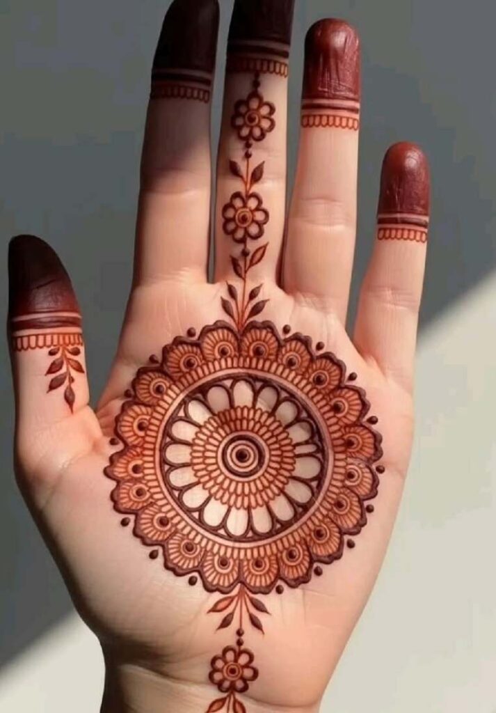 Aesthetic front hand mehndi featuring a large intricate circular mandala design in the center of the palm connected to a straight floral finger trail. - Basic Easy Front Hand Simple Mehndi Design