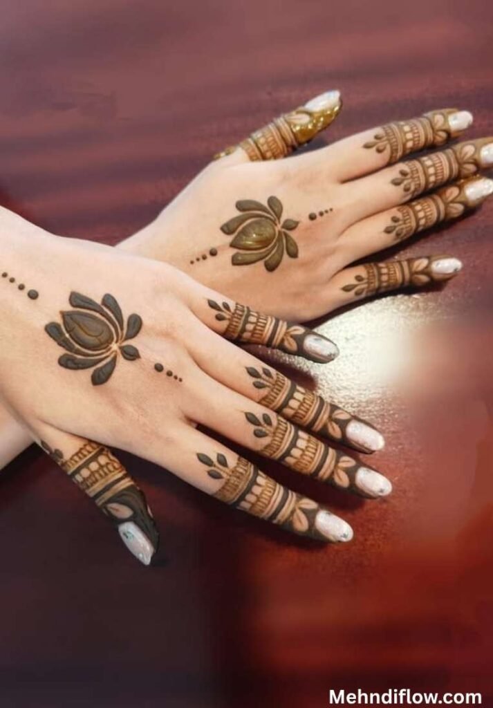 Minimalist dark brown lotus henna design on the back of both hands with geometric finger patterns.