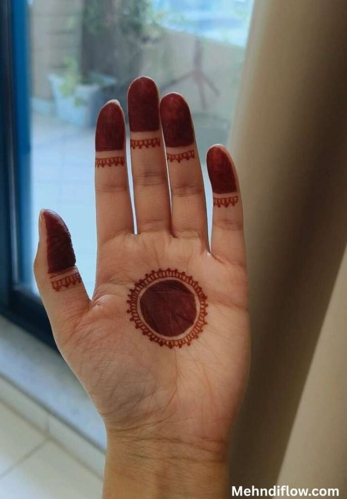 Simple concentric circle mehndi design on a single palm with traditional filled fingertips and delicate border lines.