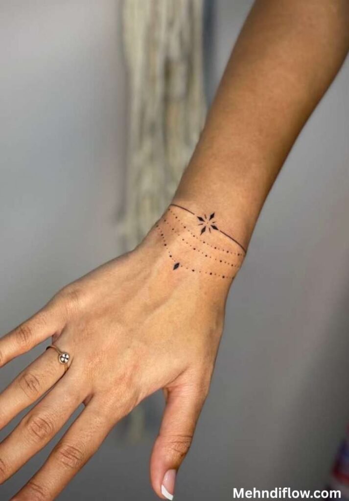 Minimalist dot bracelet henna design on a wrist featuring delicate chain lines and a central star motif.