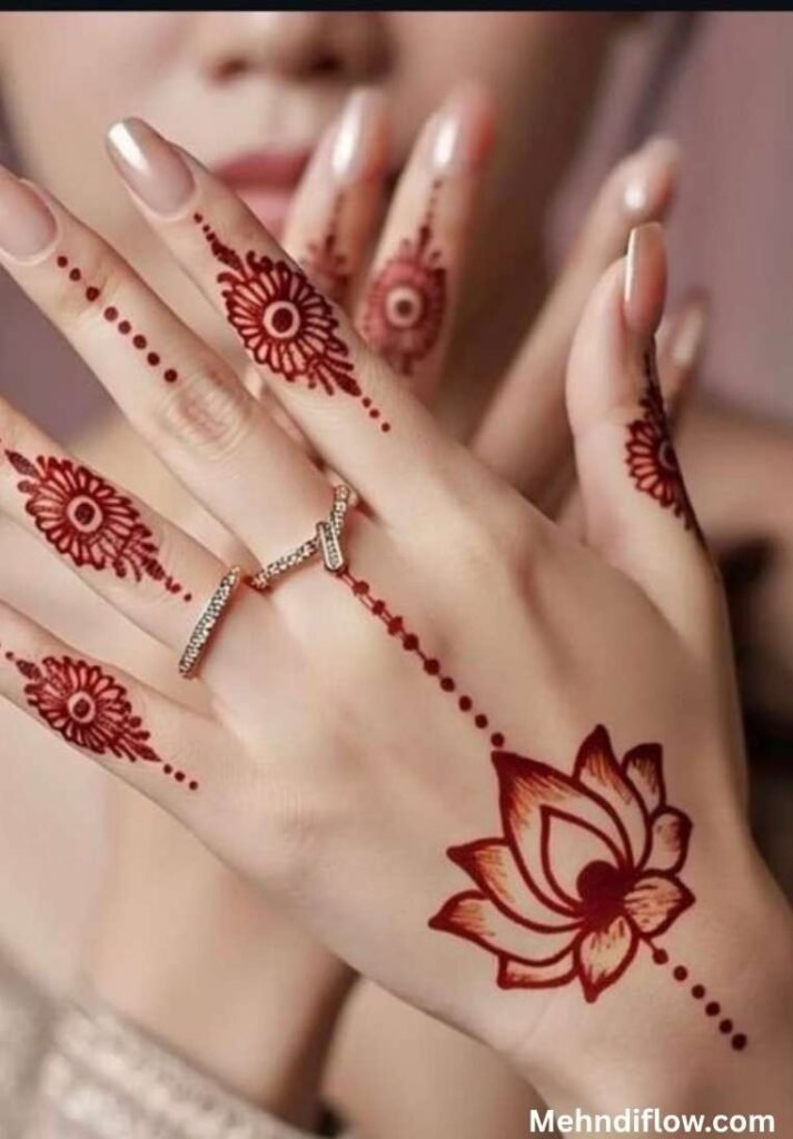 Minimalist reddish-brown lotus mehndi design on the back of the hand with delicate dotted lines and finger patterns.