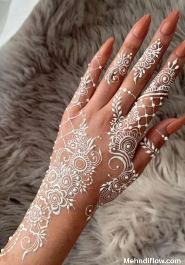 Intricate lace pattern white mehndi design featuring delicate mesh netting, swirling floral mandalas, and elegant dotted details cascading across the back of the hand and fingers.