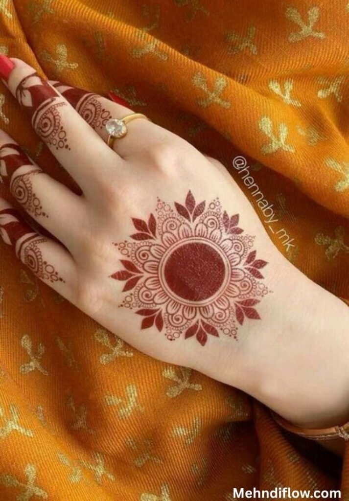 Intricate Mandala Circle mehndi design on the back of the hand with floral leaf borders and detailed finger accents.