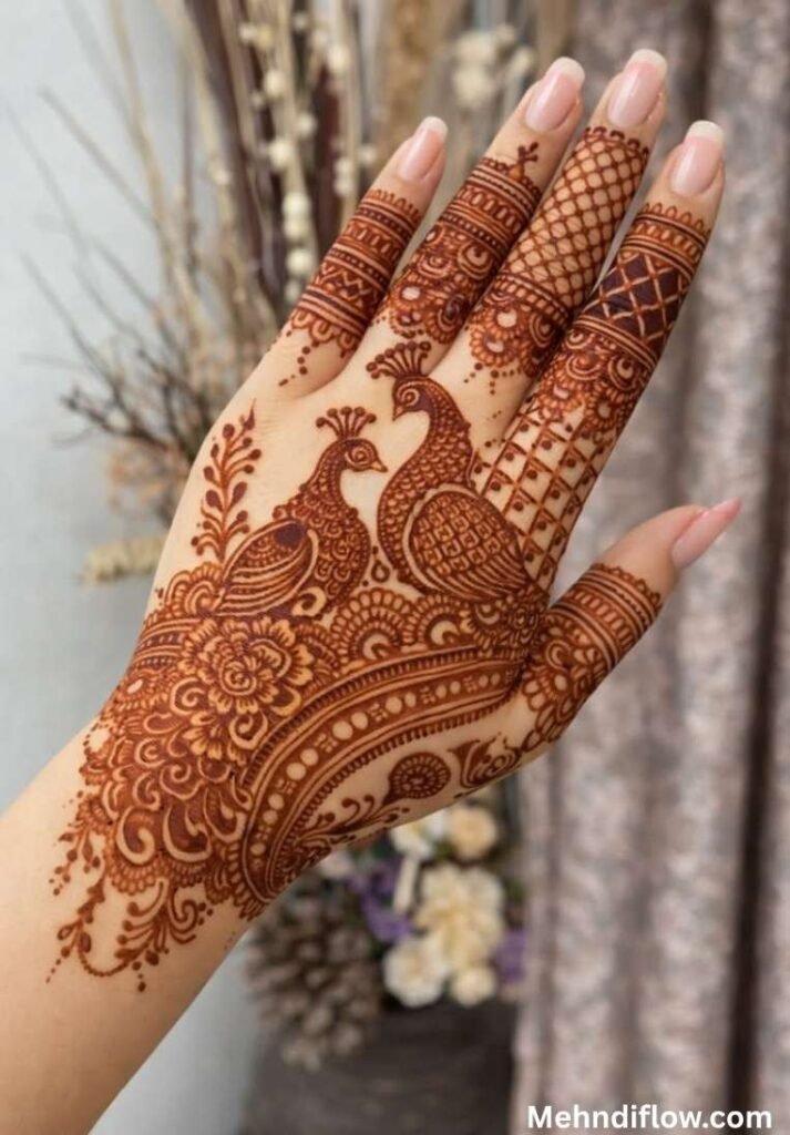 Dense full bridal mehndi design on the back of the hand showcasing a pair of detailed peacock accents nestled in intricate grid patterns.