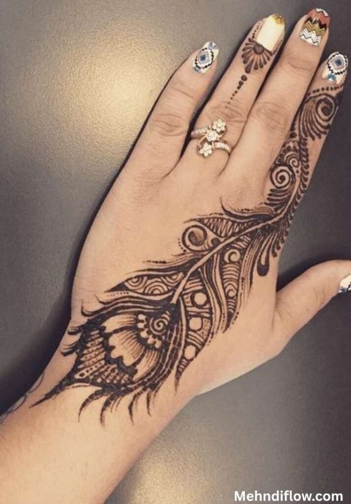 Bold Mor Pankh peacock feather henna pattern running diagonally across the back of the hand.