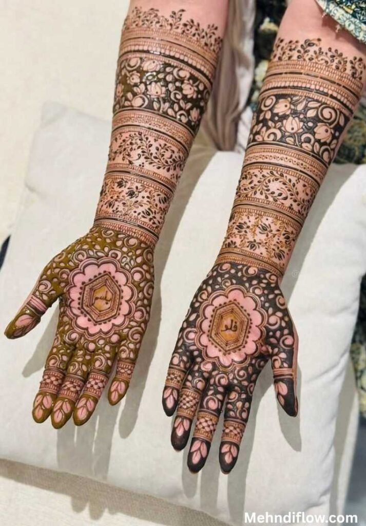 Detailed, full-coverage bridal mehndi design on the palms and forearms featuring dense floral patterns and a central geometric mandala frame enclosing personalized text.