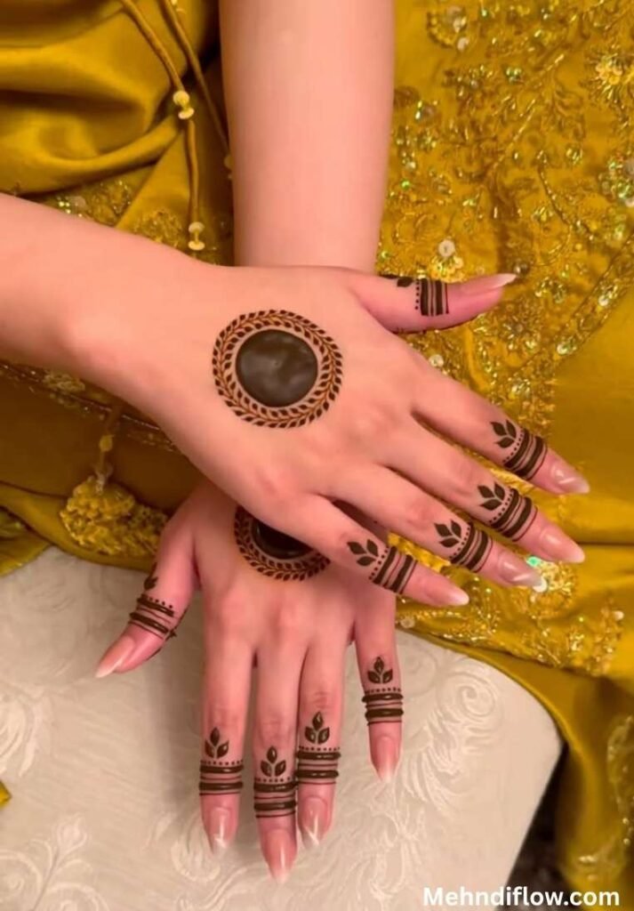 Ring-style circle mehndi design on the back of the hand with delicate leaf-patterned rings wrapped around each finger knuckle.
