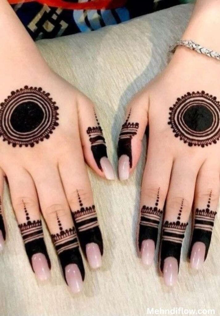 Bold mandala circle mehndi design featuring structured, geometric ring bands and dotted lines across each knuckle.