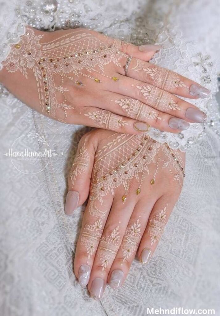 Elegant white and gold fusion mehndi design featuring delicate lace-like netting and embedded gold rhinestones across the back of the hands and fingers for a sparkling jewelry effect.