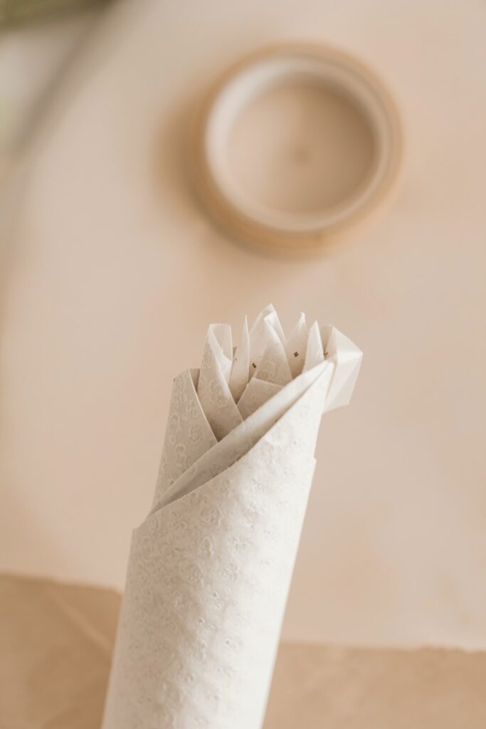 Handmade mehndi cone being folded and sealed with transparent tape

