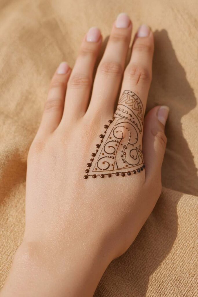  Simple boys mehndi design back hand with clean lines and small dots.
